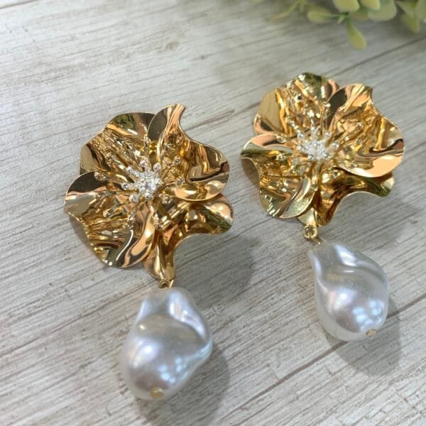 Aros flor dorada perla irregular en fantasía fina