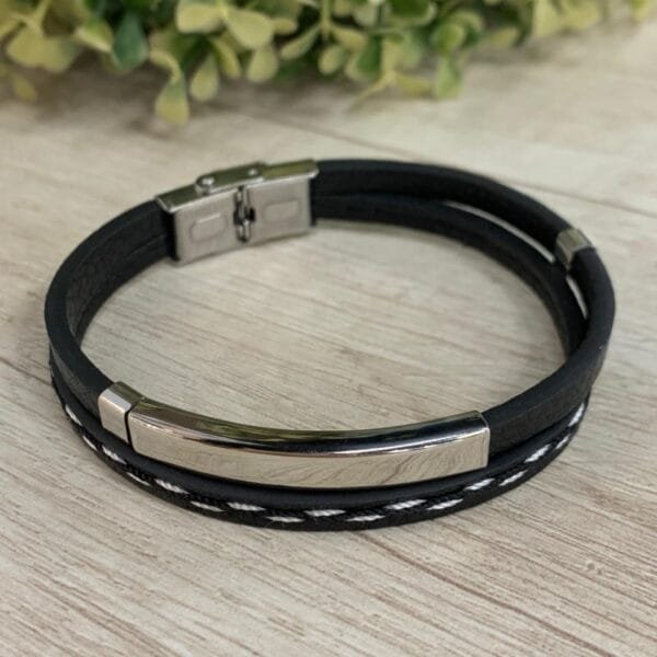 Pulsera doble negra costura blanca