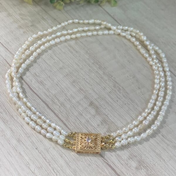 Collar triple perla de rio broche cajon baño en oro 36 cm