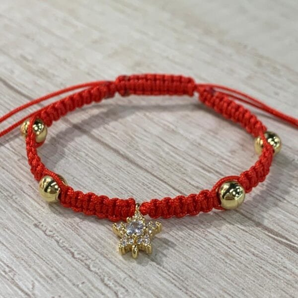Pulsera macrame roja estrella esferas baño oro