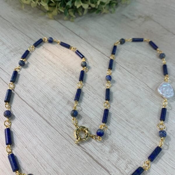 Collar lapislazuli perla barroca broche timon baño oro 79 cm