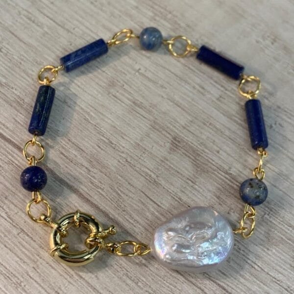 Pulsera lapislazuli perla barroca broche timon baño oro