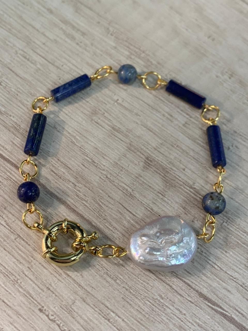 WhatsApp Image 2026-04-15 at 14.42.29 Pulsera lapislazuli perla barroca broche timon baño oro - Imagen 1