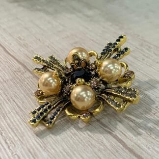 Prendedor cruz dorado con perlas