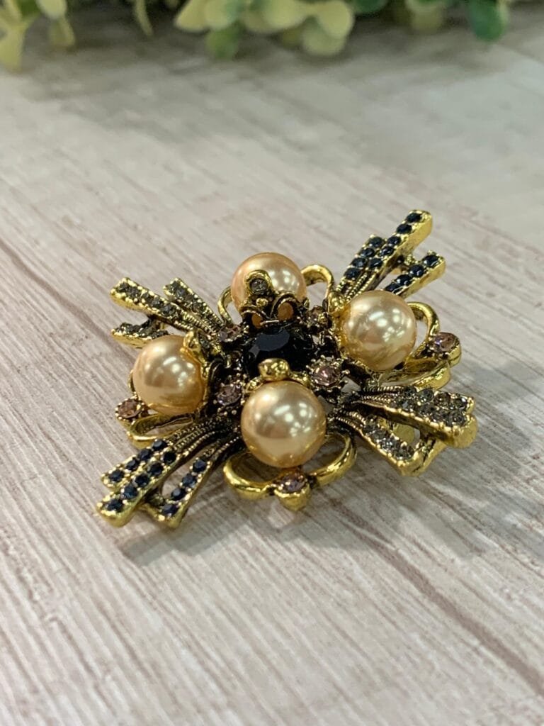 Prendedor cruz dorado con perlas