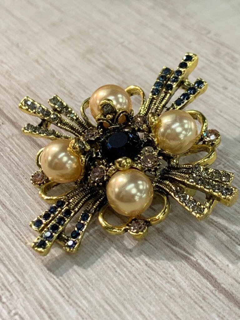 Prendedor cruz dorado con perlas