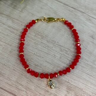 Pulsera baño en oro cristales rojos dije mano de fatima