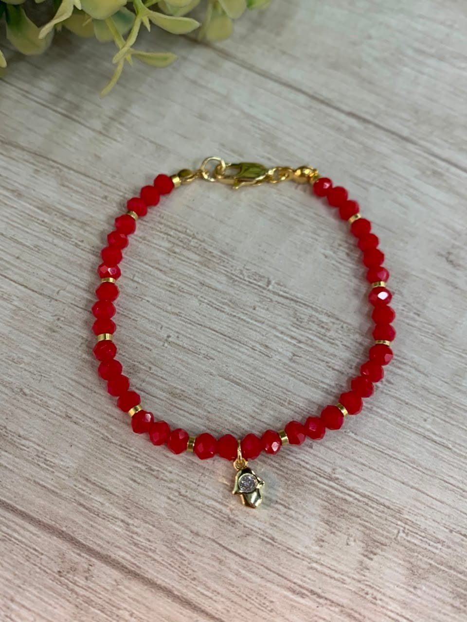 Pulsera baño en oro cristales rojos dije mano de fatima