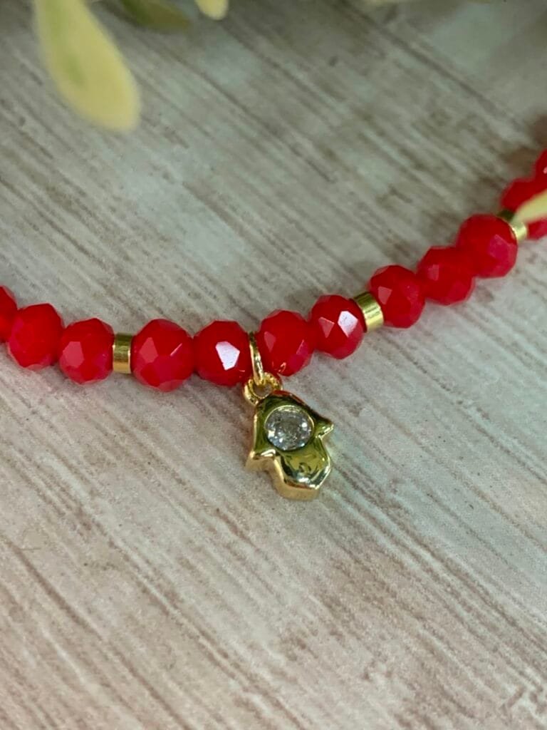 Pulsera baño en oro cristales rojos dije mano de fatima